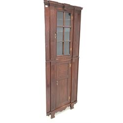 19th century architectural stained pine floor standing corner cupboard, the top section fitted with a glazed door enclosing three shelves over panelled cupboard to base W84cm