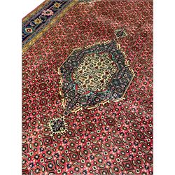 Persian Arrak red ground rug, the field with central medallion surrounded by Heratti motifs, matching spandrels, multi-band border decorated with stylised plant motifs and flower heads