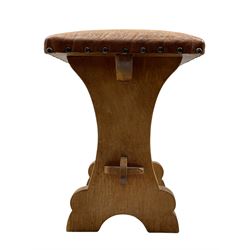 'Gnomeman' oak stool, shaped end supports joined by pegged stretcher, the seat upholstered in leather with studs, carved with gnome signature, by Thomas Whittaker of Littlebeck