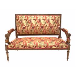 Victorian walnut settee, the rectangular back and seat upholstered in red and gold coloured fabric, show rail carved with repeating floral motif, open arms with seraph carved arm terminals, raised on turned and fluted supports  W140cm
