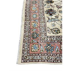 Persian Meshed ivory ground carpet, the field decorated with interlaced branches and stylised plant motifs with birds, peach ground scrolling border with repeating floral motifs within guard bands