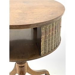 20th century Regency design mahogany drum table, the circular revolving top having faux books and recesses for further books, raised on turned column and three inverted splayed supports terminating in brass castors