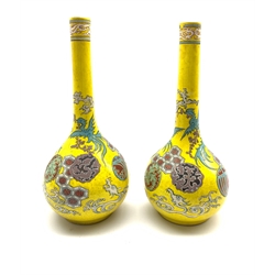 Pair of Japanese Meiji period bottle shaped vases decorated with Dragons amidst clouds and mon on yellow ground, one bearing an old Antiques label, H25cm 