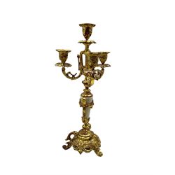 Late 19th century alabaster and gilt figural mantel clock garniture, with a French 8-day countwheel striking movement striking the hours and half hours on a bell, white enamel dial with Arabic numerals and floral garland to the centre, with a  pair of  conforming three branch, four light candle sticks.
With pendulum.