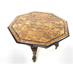 Victorian Aesthetic period centre table, the octagonal burr walnut top with boxwood string inlay, ebonised and amboyna banding and bordered by moulded ebonised edge over shaped apron with applied floral carved roundels, raised on four turned and fluted supports united by cross stretcher, brass and ceramic castors, 114cm x 114cm, H74cm