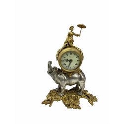 Decorative spring driven two train mantle clock striking the hours on two bells, enamel dial with roman numerals and five-minute Arabic’s, with minute markers and louis’ XV hands, dial inscribed “Imperial”, balance wheel eight-day movement housed in a decorative drum case resting on a silvered cast metal figure of an elephant with figure above. With key