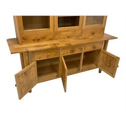 Treske Furniture - figured and burr oak dresser, the upper section enclosed by three glazed doors over three drawers, the lower section with rectangular top over three drawers and three panelled cupboards, on turned tapering supports