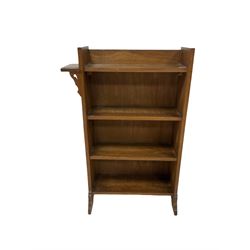 Oak bookshelf with three fixed shelves raised on panel end supports 