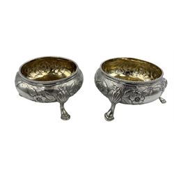 Pair of Victorian silver circular salts with gilded interiors, embossed with flowers and leaves on triple shaped supports London 1853 Maker William Robert Smily