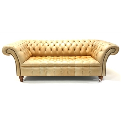 Late 20th century three seat Chesterfield sofa, upholstered in deep buttoned tan leather, raised on turned walnut supports, W221cm, H78cm, D105cm