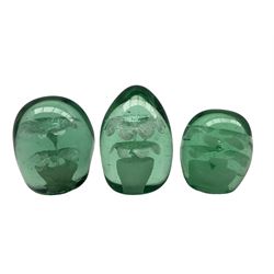 Victorian green glass dump paperweight with flower pot inclusion H11cm and two smaller, similar paperweights (3)