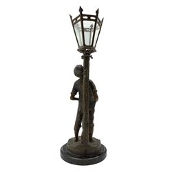 French patinated spelter table lamp modelled as a boy leaning against a street lamp, on circular marble plinth, H54cm overall