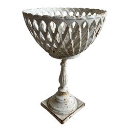 White painted cast iron flower basket stand, the latticework basket on turned and reeded stem, circular footed base