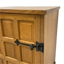 Beaverman - adzed oak cupboard, enclosed by panelled door with wrought metal catch, adzed top and size, the interior fitted with shelf and divisions, on square tapering feet, carved with beaver signature, by Colin Almack, Sutton-under-Whitestone Cliffe, Thirsk