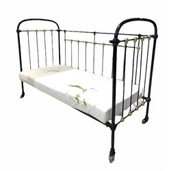 Victorian child's cot, the black and gilt painted wrought iron frame raised on castors, with a later foam mattress L137cm