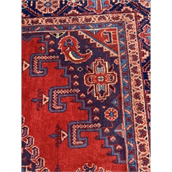 Persian rug carpet, red field with blue medallion and two lozenge medallions, guarded border decorated with stylised flower heads, 346cm x 224cm