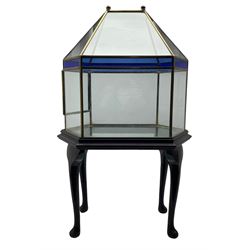 Victorian style hexagonal glass terrarium, of architectural form with blue stained glass panels, two brass knop finials and frame, raised on fitted wooden stand with cabriole supports, H90cm, W53cm, D37cm approx
