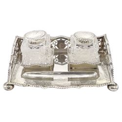 Late Victorian silver inkstand of serpentine outline with three quarter pierced gallery fitted with two glass inkwells with silver covers engraved with the crest of Viscount Helmsley and on compressed bun feet W18cm Chester 1900/1 Makers George Nathan and Ridley Hayes.
Provenance: 2nd Earl of Feversham