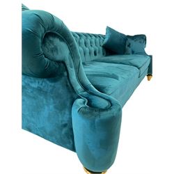 Chesterfield style three seat sofa, scrolled arms and uprights, upholstered in buttoned teal velvet, on turned tapering brass finish feet