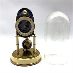 Kaiser Universal torsion clock , the astrological dial with a rotating moon phase ball, the `400-day` movement with a rotating globe pendulum, raised on cream lacquered pillars on a circular base, under a glass dome, H27cm
