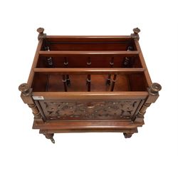 Victorian mahogany Canterbury or magazine rack, finias to each corner, three divisions with spindle uprights, the front panel pierced with foliate fretwork, over a cavetto apron, raised on turned feet with brass castors