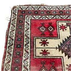 Persian crimson ground rug, the field with three pale ground crosses, decorated with geometric motifs, repeating border within guard stripes