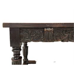 17th to 18th century oak refectory table, rectangular fold-over top over the frieze rail carved with a central cartouche with scrolling foliate and berries, sliding front rests with acanthus carved corbel mounts, turned fluted supports with foliate scroll carving, joined by moulded stretcher rails, foliage scroll and floral carved side frieze rails and plain back, the back rail with plain sliding rests