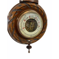 An Edwardian carved pendant framed hall barometer with a compensated Aneroid movement by the German maker Julius Gischard, open porcelain four-and-a-half-inch dial measuring barometric air pressure from twenty-seven to thirty-one point nine inches, weather predictions written in upper and lower case gothic script with initial letters highlighted in red, blue steel indicating hand and brass recording hand, dial bezel with flat bevelled glass, mercury thermometer recording temperature in degrees Fahrenheit and Celsius, scale written in red Arabic numerals on an unglazed opal plate with arched crest above, Julius Gischard was one of the five traditional Hamburg barometer manufacturers whose history dates back to the 19th century, founded in 1874 by Christian Julius Friedrich Gischard and his companion J. Heinrich Saul, the company manufactured and exported many barometers to England during the 19th and 20th century.
