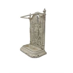 Victorian white painted cast iron stick or umbrella stand and drip-tray, the pierced back with central garland and scrolling foliate design, flanked by spiral turned pilasters topped by reeded finials