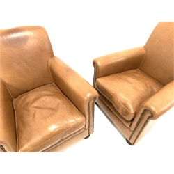 Pair of armchairs, upholstered in studded tan leather, raised on turned front supports 