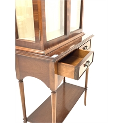 Georgian design mahogany display cabinet, raised back with fan inlay over two bevelled glazed doors enclosing two adjustable glass shelves, two drawers under, raised on turned supports united by under tier 