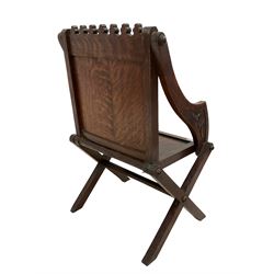 Late 19th century gothic revival oak Glastonbury chair, cresting rail carved with repeating club decoration over panelled back carved with foliate lozenge and arcade design, sloped arms and panelled seat raised on X supports