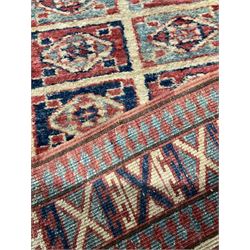 Persian design red ground runner rug, the field decorated with rectangular panels of indigo and red containing lozenge motifs, guarded border with repeating cross patterns
