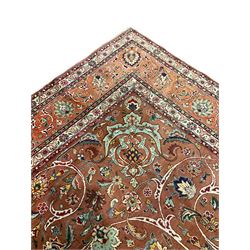 Persian carpet, rust ground field decorated with sweeping scrolls and stylised plant motifs, large floral design central medallion, repeating scrolling border with stylised flower head motifs 