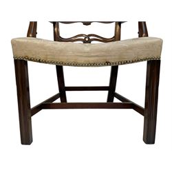 George III mahogany elbow chair, pierced and waived ladder back with foliate carved ears, moulded uprights and serpentine arms carved with trailing foliate, dished upholstered seat with stud band, on moulded front supports joined by H-shaped stretchers
