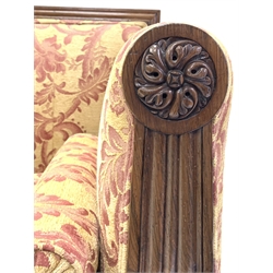 Early 19th century rosewood sofa, moulded crest rail and leaf carved arm terminals with floral roundels, back, seat, arms, and squab cushion upholstered in Nina Campbell pale gold fabric, raised on turned and lobe carved supports terminating in brass castors