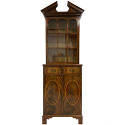 Georgian design mahogany cabinet, the broken sloped arch and dentil cornice over glazed door enclosing lined interior, fitted with two drawers and double cupboard, on bracket feet
