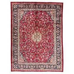 Persian Mahal red ground carpet, the field decorated all-over with scrolling branch and stylised flower head motifs, the main border band decorated with flower heads and scrolling foliage