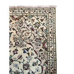 Persian Kashan ivory ground rug, the central floral pole medallion with extending palmettes and interlacing foliate designs, the triple band border decorated with repeating stylised flower heads