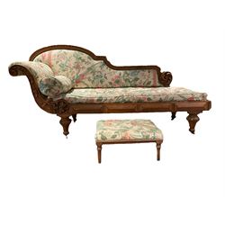 19th century oak chaise longue, shaped back with egg and dart carved edge with acanthus leaf scrolled roundel, scrolled back carved with trailing bell flower heads, upholstered in neutral ground fabric decorated with floral and bird pattern, the frieze rail with faceted panel mounts, turned and egg and dart carved feet with brass and ceramic castors, with footstool