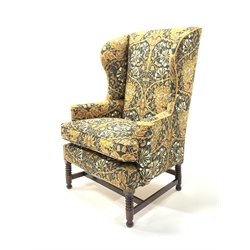 Early 19th century wing back armchair, upholstered in William Morris style liberty honeysuckle fabric, raised on ring turned mahogany supports 