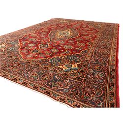 Small Persian Ardakan red ground rug, the field decorated with stylised peony and plant motifs, scrolling border