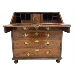 George II figured walnut bureau, the rectangular top crossbanded and with satinwood feather-banding, the fall-front supported with stays, opening to reveal fitted interior with central cupboard door flanked by fluted pilasters and pigeonholes with drawers to each side, below are four graduating drawers with cock-beaded facias, the bureau's secret sliding door gives access to the top drawer, raised on turned feet below the moulded frieze