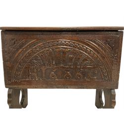 Charles II small carved oak box, rectangular hinged top with moulded edge, front carved with central lunette motif with concentric rings with central acanthus detail, 1686 moulded below, on shaped end supports