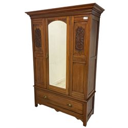 Late Victorian walnut double wardrobe, projecting cornice over arched bevelled mirror door flanked by foliate carved panels, enclosing hanging rail and coat hooks, single drawer to base