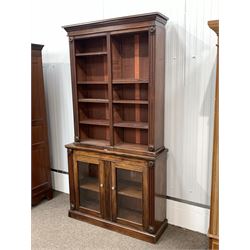 Early Victorian mahogany library bookcase on cupboard, projecting cornice over applied floral roundels and egg and dart beading, fitted with eight open shelves, two glazed doors each enclosing a shelf under, raised on skirted base W118cm, H230cm, D40cm