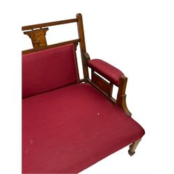 Late Victorian rosewood settee, inlaid with cartouche motifs with trailing bell flowers, upholstered in red fabric, on square taping supports with spade feet