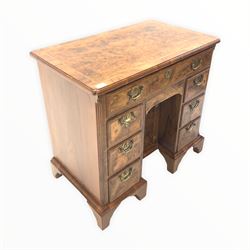 20th century Queen Anne style walnut knee hole desk, the cross banded burr top with herringbone inlay over one long and seven short drawers centred by a cupboard, raised on bracket supports W82cm x 48cm, H77cm