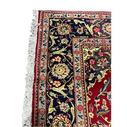 Persian Kashan red ground rug, the field decorated with interlacing foliate design, blue ground floral central medallion and spandrels, scrolling border decorated with stylised plant motifs