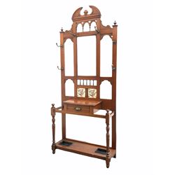 Edwardian walnut hallstand, fitted with six hangers surrounding one central mirror and two floral tiles with glove drawer over two umbrella and stick stands raised on turned supports W90cm, H220cm, D33cm